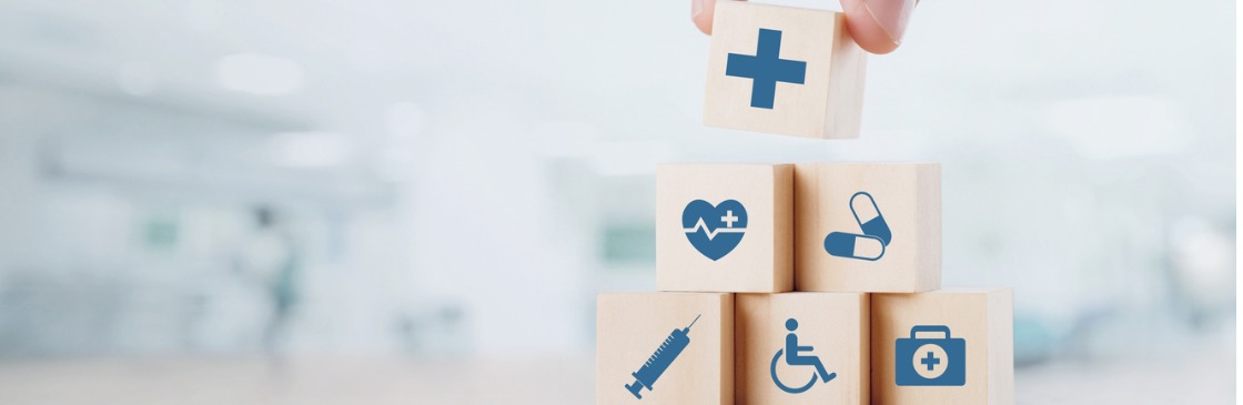 Close up man hand arranging wood block with healthcare medical icon on hospital background. Health care and Health insurance concept.